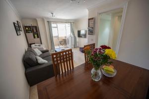 a living room with a table with flowers and a couch at Bright and central 2 bedroom flat in Gibraltar in Gibraltar