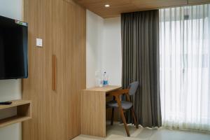 a room with a desk with a chair and a television at The Trios Hotel in Cochin