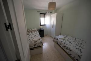 a small room with two beds and a window at Bright and central 2 bedroom flat in Gibraltar in Gibraltar