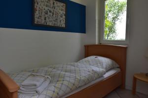 - une chambre avec un lit, une couverture et une fenêtre dans l'établissement Inselhof Steengrafe - Weserblick, à Schwanewede