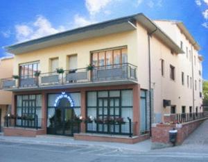 un gran edificio con balcones en la parte superior. en Albergo La Posta Arezzo, en Badia Al Pino