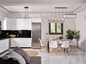 una cucina e una sala da pranzo con tavolo e sedie di Kapodistria Luxury Villas a Plános