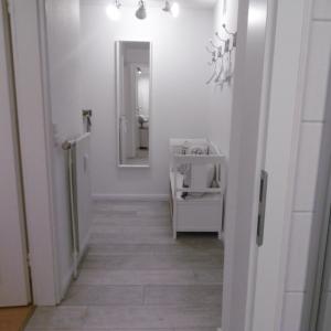 a hallway with white walls and a mirror and a hallway sidx sidx at FöhrZeit in Wrixum