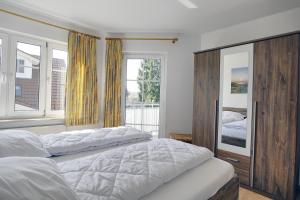 a bedroom with a large bed and two windows at Wohnung Central FW 4 mit Balkon in Zingst