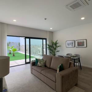 a living room with a brown couch and a table at PALHOTAS GUEST HOUSE - Apartamento Jardim Santa Bárbara in Braga