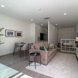 a living room with a couch and a table at PALHOTAS GUEST HOUSE - Apartamento Jardim Santa Bárbara in Braga