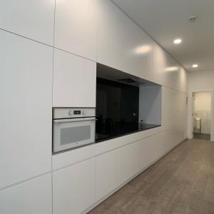 a kitchen with white walls and a stove at PALHOTAS GUEST HOUSE - Apartamento Jardim Santa Bárbara in Braga