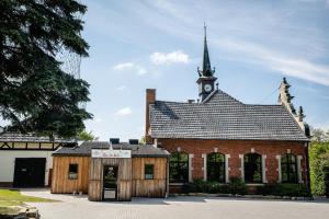 un ancien bâtiment en briques avec une tour d'horloge dans l'établissement Alte Schule Spittelstein 1OG links - a22964, à Rödental