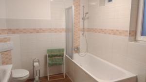 ein Badezimmer mit einer Badewanne, einem WC und einem Waschbecken in der Unterkunft FeWo am Uenglinger Tor in Stendal