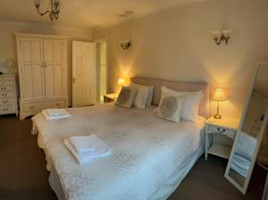 a bedroom with a white bed with two towels on it at Orchard Cottage 