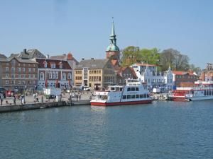 a group of boats docked in a harbor with buildings at Fewo Glücksburg in Ulsnis