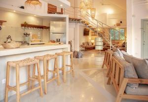 a kitchen and living room with a couch and stools at Tropical Penthouse in the Heart of Las Terrenas! in Las Terrenas