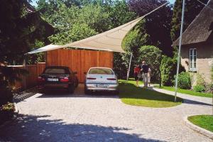 two cars parked in a driveway with a white umbrella at Altes Rektorenhaus 1 in Rieseby