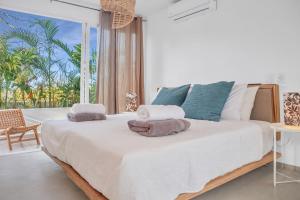 a bedroom with a large bed with towels on it at Tropical Penthouse in the Heart of Las Terrenas! in Las Terrenas +40 photos