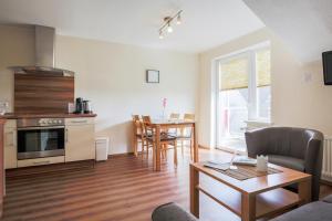 a living room with a kitchen and a dining room at Ferienhof Büdlfarm - Süd Ost in Sahrensdorf