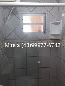 espejo en el baño con ventana en Apartamento Praia dos Ingleses, 100 mt do mar, en Florianópolis