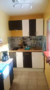 a kitchen with white cabinets and black appliances at Bungalow charmant à Pointe-Noire avec piscine partagée in Pointe-Noire