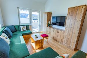 a living room with a couch and a tv at Happy Aich 4 by Alpenidyll Apartments in Aich