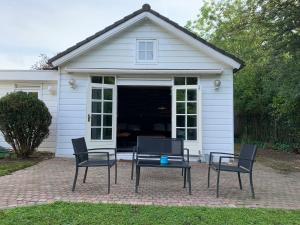 a patio with chairs and a table in front of a house at Sleepzzz in Heusden