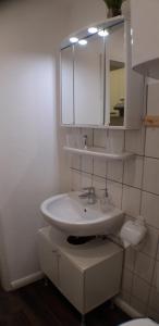 La salle de bains est pourvue d'un lavabo blanc et d'un miroir. dans l'établissement Gleis acht, à Bredstedt