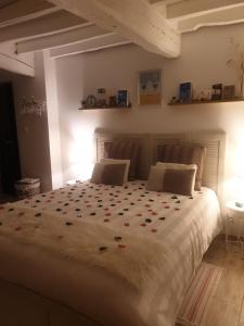 una camera da letto con un grande letto bianco con fiori di Le Romarande, Cottage détente avec SPA privatif a Heubécourt