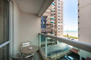 a balcony with a table and a view of the ocean at Hotel Santorini in Vila Velha