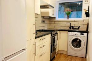 a kitchen with a washing machine and a washer at The Nook - A stylish apartment with garden, near the beach in Berwick-Upon-Tweed