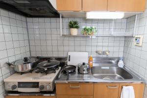 a kitchen with two pots and a sink at stay's ジローズ浄心 601号 名古屋 民泊 駅近 in Nagoya