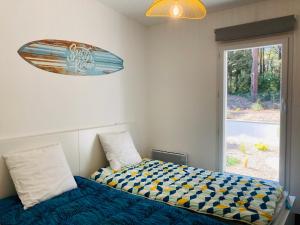 a bedroom with a bed with a surfboard on the wall at Maison de la forêt, terrasse plein sud et standing in Saint-Jean-de-Monts