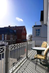 - Balcón con mesa y silla en un edificio en Haus Hansen - Wyk Whg 02, en Wyk auf Föhr