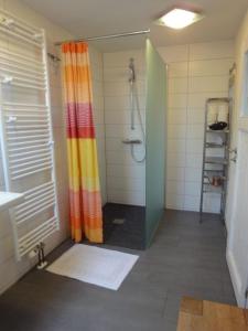 a shower with a colorful shower curtain in a bathroom at OG Stetten 