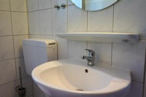bagno con lavandino bianco e specchio di "Deichhaus" App 3 - Cheyenne - 100 m zum Strand a Grömitz
