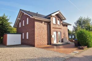 a red brick house with a white garage at Huus bi de Kark OG in Dahme