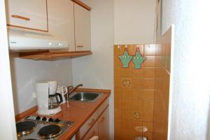 a small kitchen with a sink and a stove at Plass, FP I-5-3 in Heiligenhafen