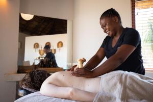 une femme qui reçoit un massage dans une chambre dans l'établissement Unembeza Boutique Lodge & Spa, à Hoedspruit