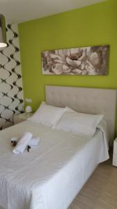 um quarto com uma cama branca e uma parede verde em Apartamento LAUMA em Benalúa de Guadix