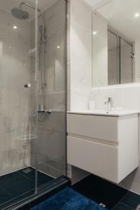 a bathroom with a sink and a glass shower at The Avery Loft at Embassy Gardens, Cantonments in Accra