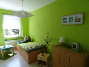 Grünes Zimmer mit einem Bett und einem Fenster in der Unterkunft Ferienwohnung Kerstin in Wienrode