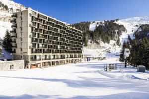 um grande edifício na neve numa pista de esqui em Residence Aldebaran - maeva Home em Flaine