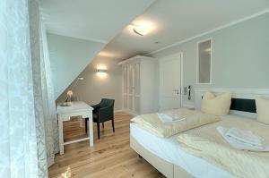 a small bedroom with a bed and a desk at MeerZeit - 21843 in Zingst