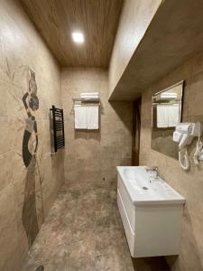 uma casa de banho com um lavatório branco e um espelho. em Central Hotel Gyumri em Guiumri