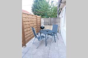 a small patio with a table and chairs in a backyard at Charmante maison cosy T2 avec terrasse in Tremblay-En-France