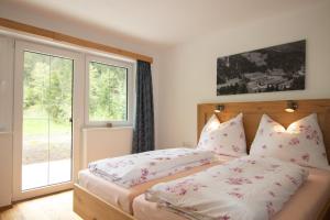 a bedroom with a bed with pillows and a window at Ferienwohnung zur Kundler Klamm WILD010 in Dorf