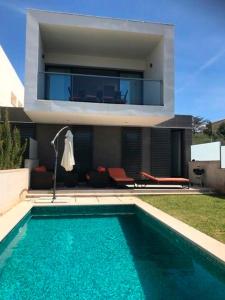 a house with a swimming pool in front of a house at Luxus Chalet Casas blancas in Cala Mendia