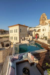 a large swimming pool in a building with a couch at Exedra Cappadocia in Ortahisar