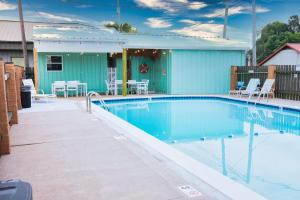 a swimming pool in front of a building with a house at Regency Inn of Eddyville Kuttawa in Eddyville