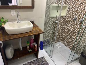 a bathroom with a sink and a shower at CASA OTTON - Casa aconchegante, 3 quartos com cama de casal todos com ar condicionado in Gramado