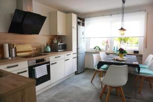 a kitchen with a table and a kitchen with white cabinets at Ferienwohnung Schott in Marktredwitz