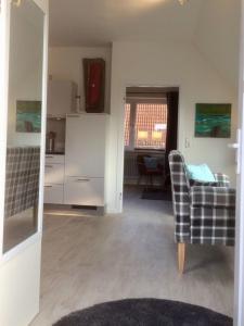 ein Wohnzimmer mit 2 Stühlen und eine Küche in der Unterkunft Ferienhaus an der Buche - 72952 in Neue Tiefe Fehmarn