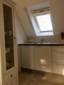eine Küche mit einem Waschbecken und einem Fenster in der Unterkunft Ferienhaus an der Buche - 72952 in Neue Tiefe Fehmarn